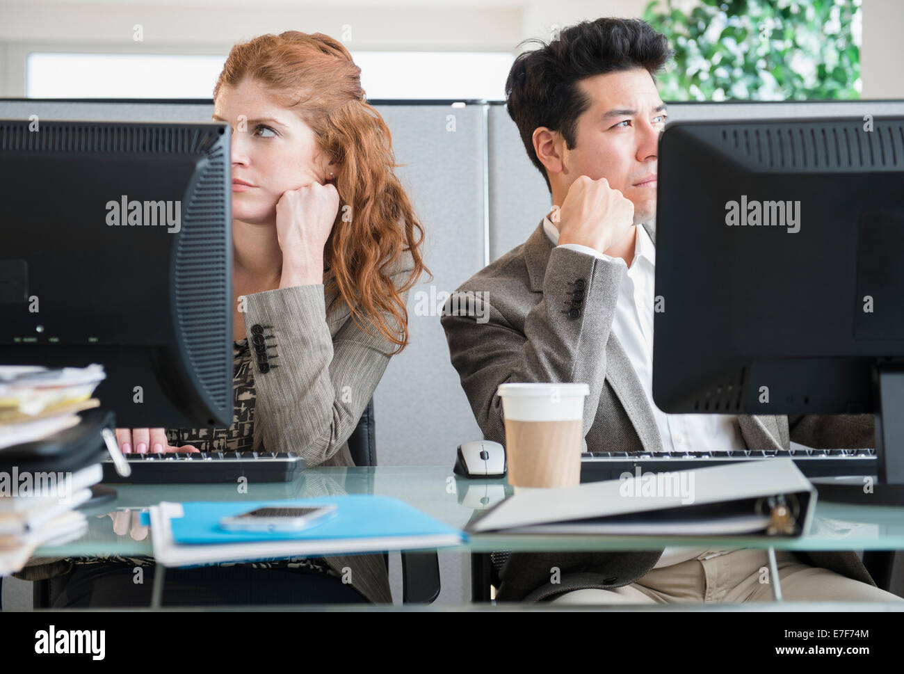 Business people bored at desks Stock Photo