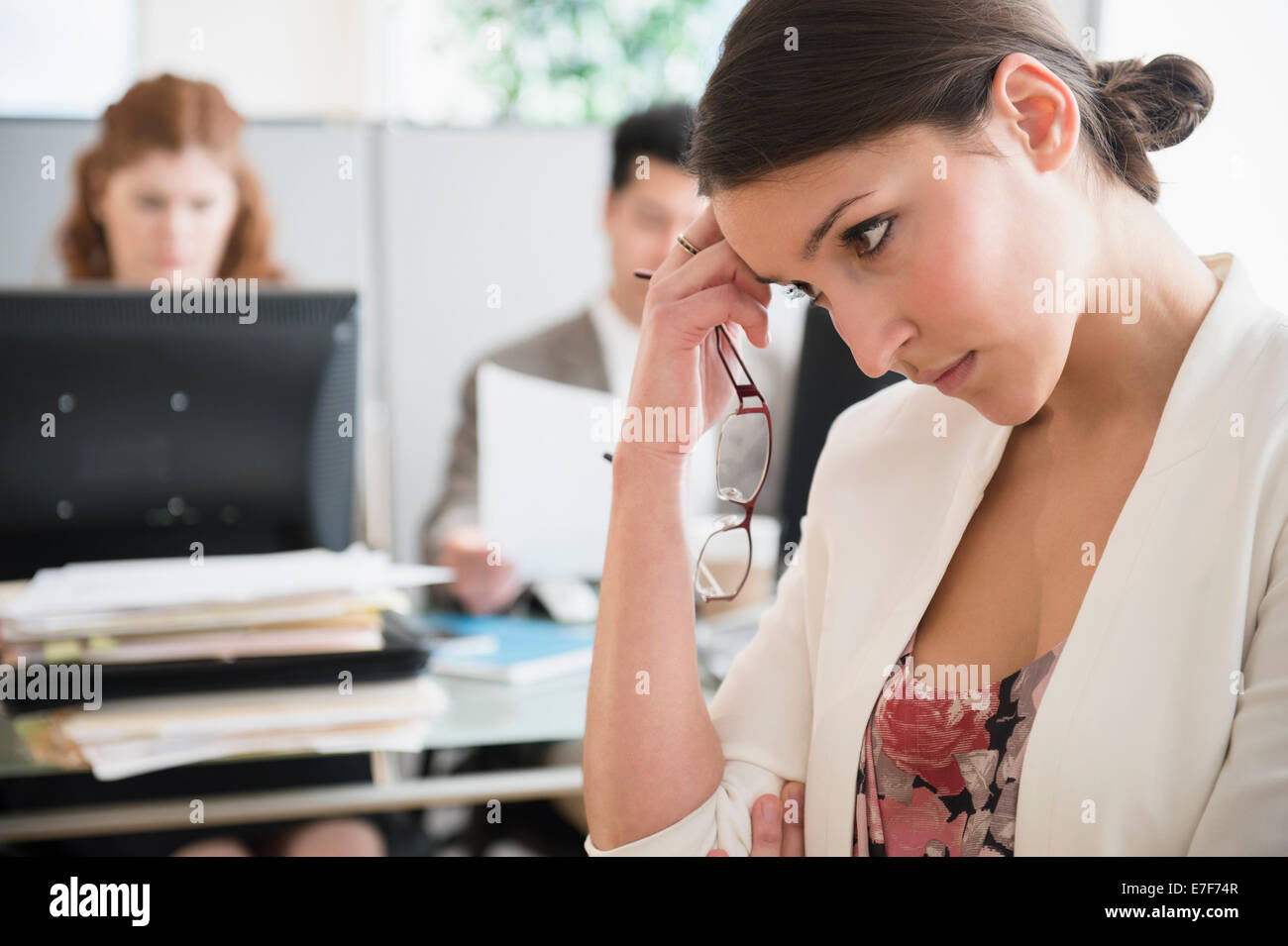 Businesswoman scratching her head in office Stock Photo