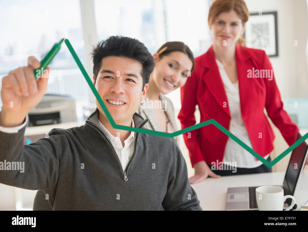 Businessman drawing graph on window in office Stock Photo
