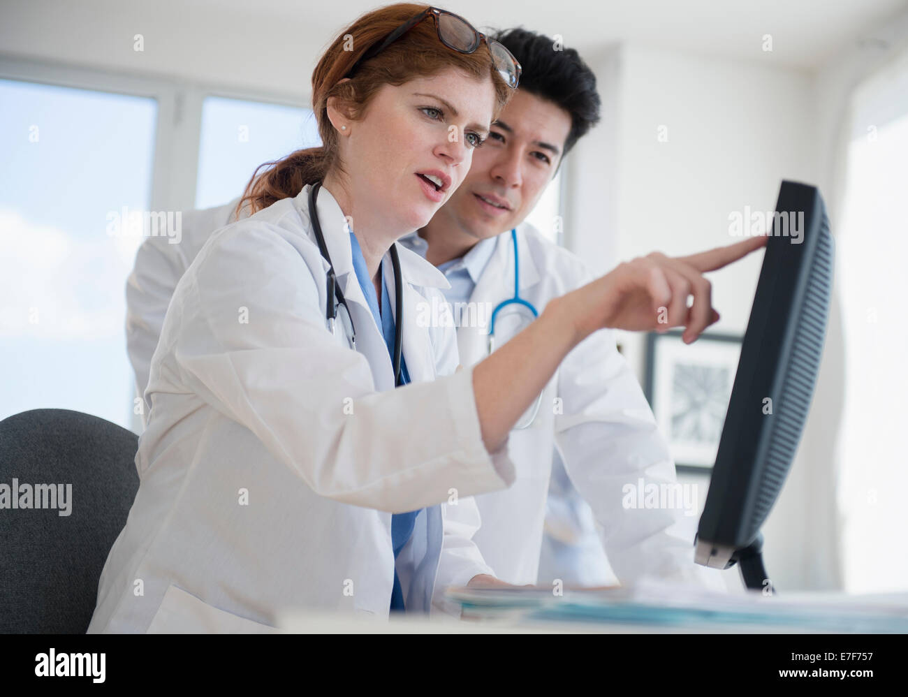 Doctors using touch screen computer in office Stock Photo