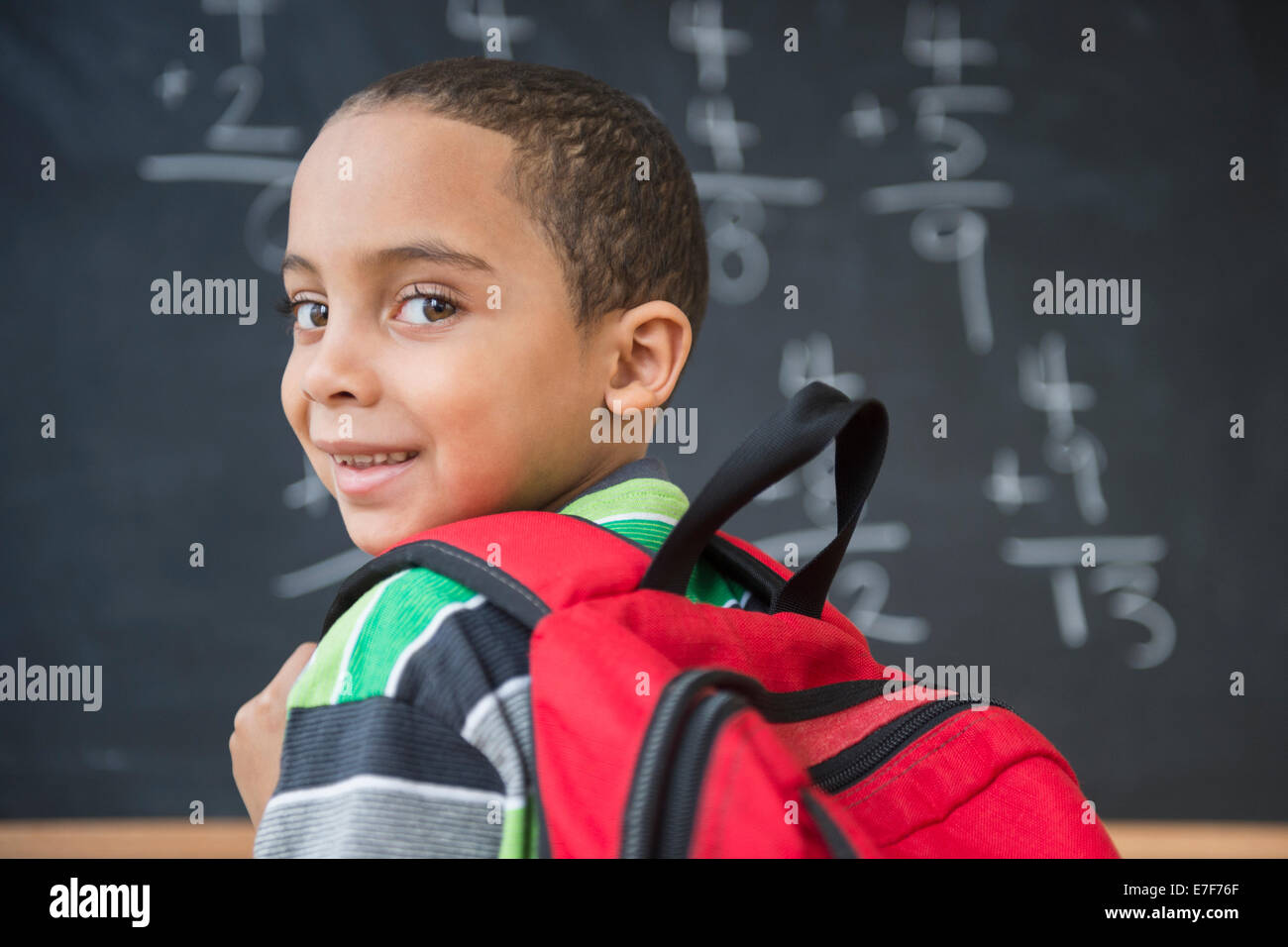 Mixed race boy doing math problems at board in class Stock Photo