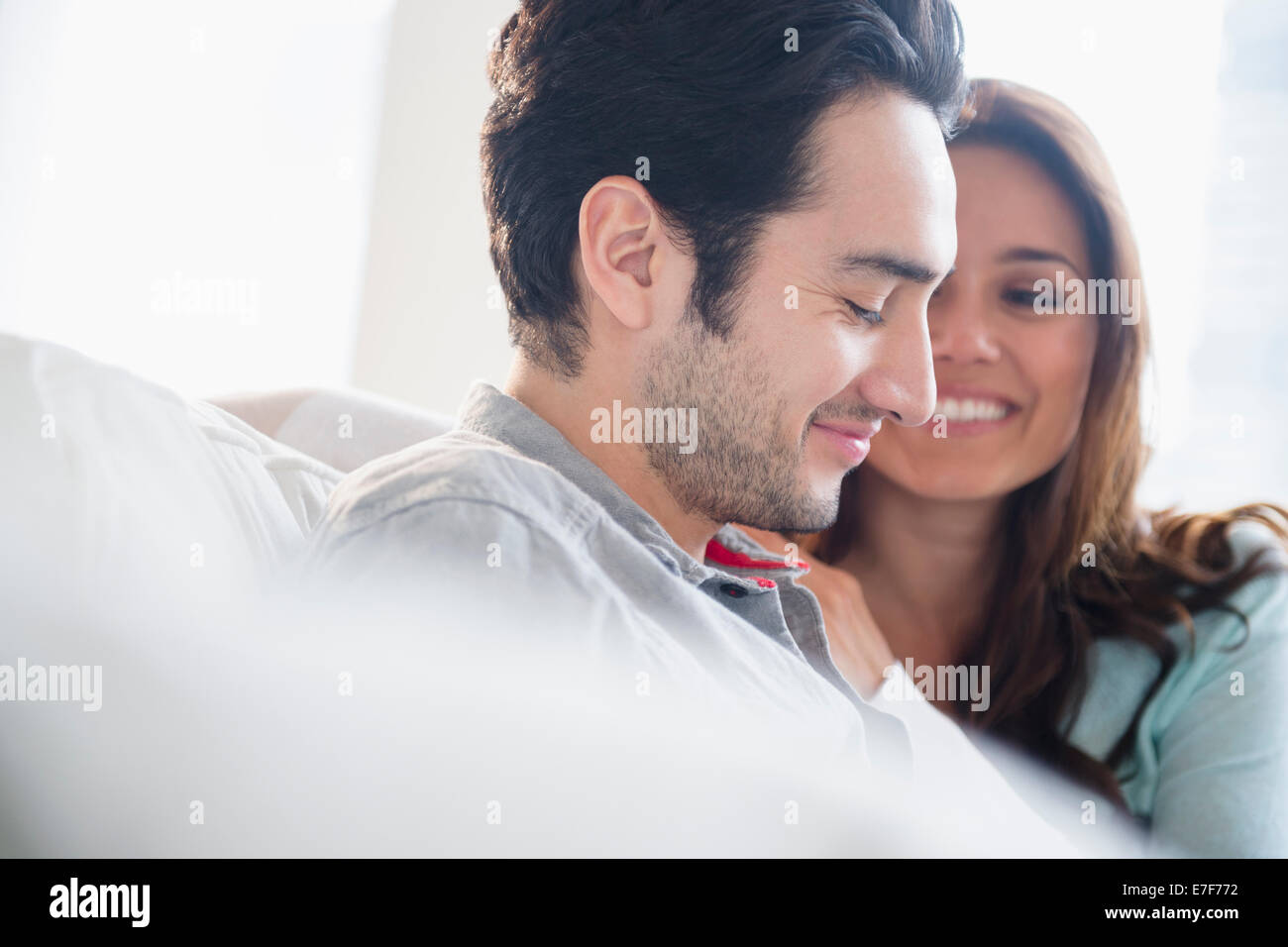 Couple smiling together on sofa Stock Photo