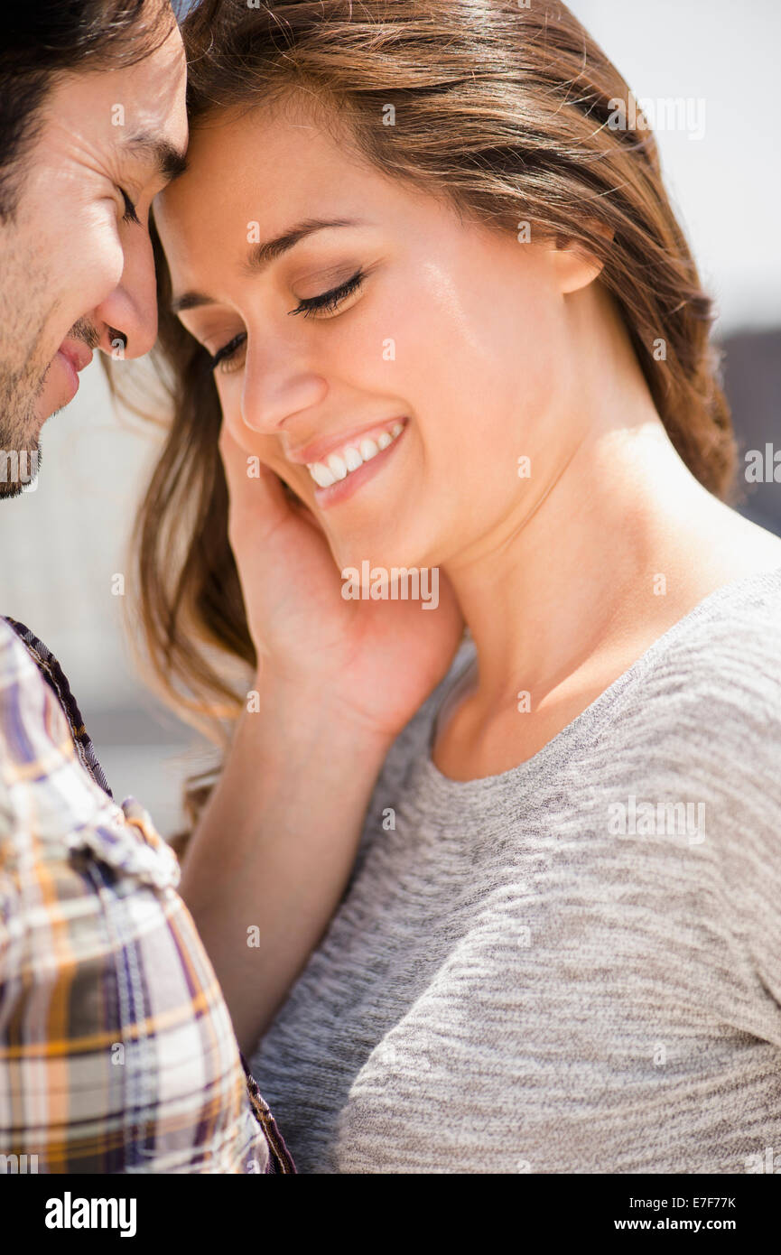 Smiling man caressing face of woman Stock Photo