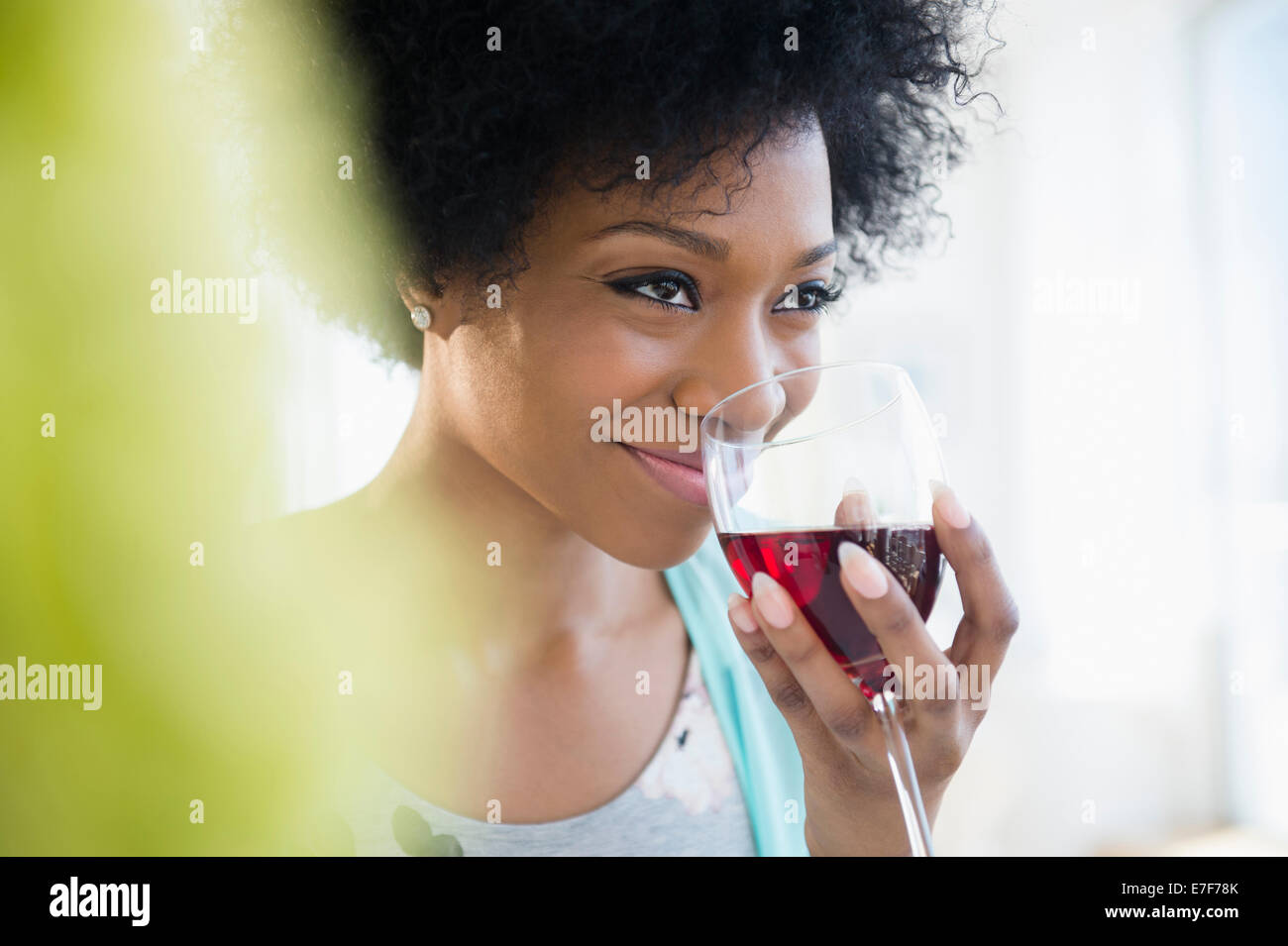 African American woman drinking glass of wine Stock Photo