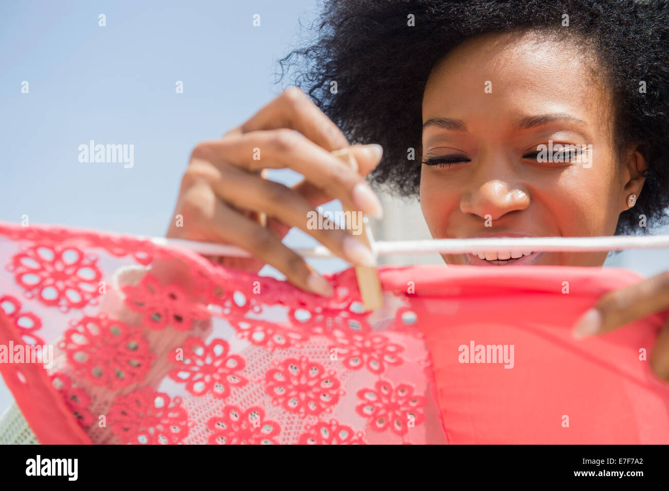 African American woman hanging laundry on clothesline Stock Photo
