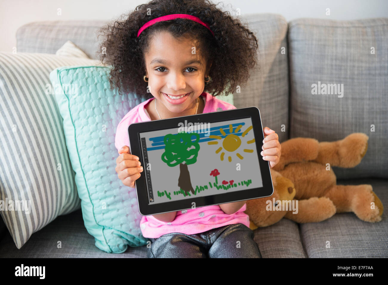 African American girl showing drawing on tablet computer Stock Photo