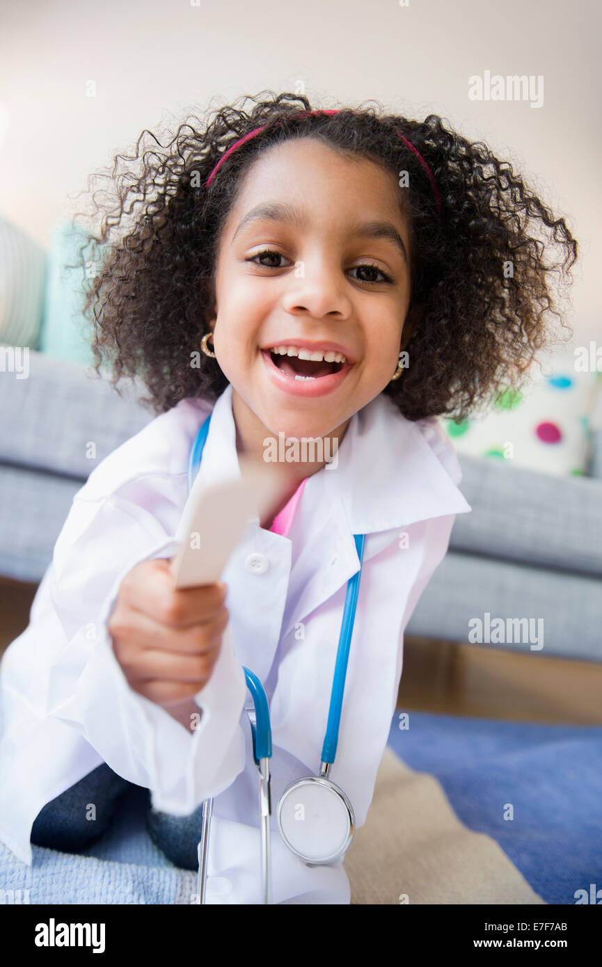 African American girl playing doctor in living room Stock Photo