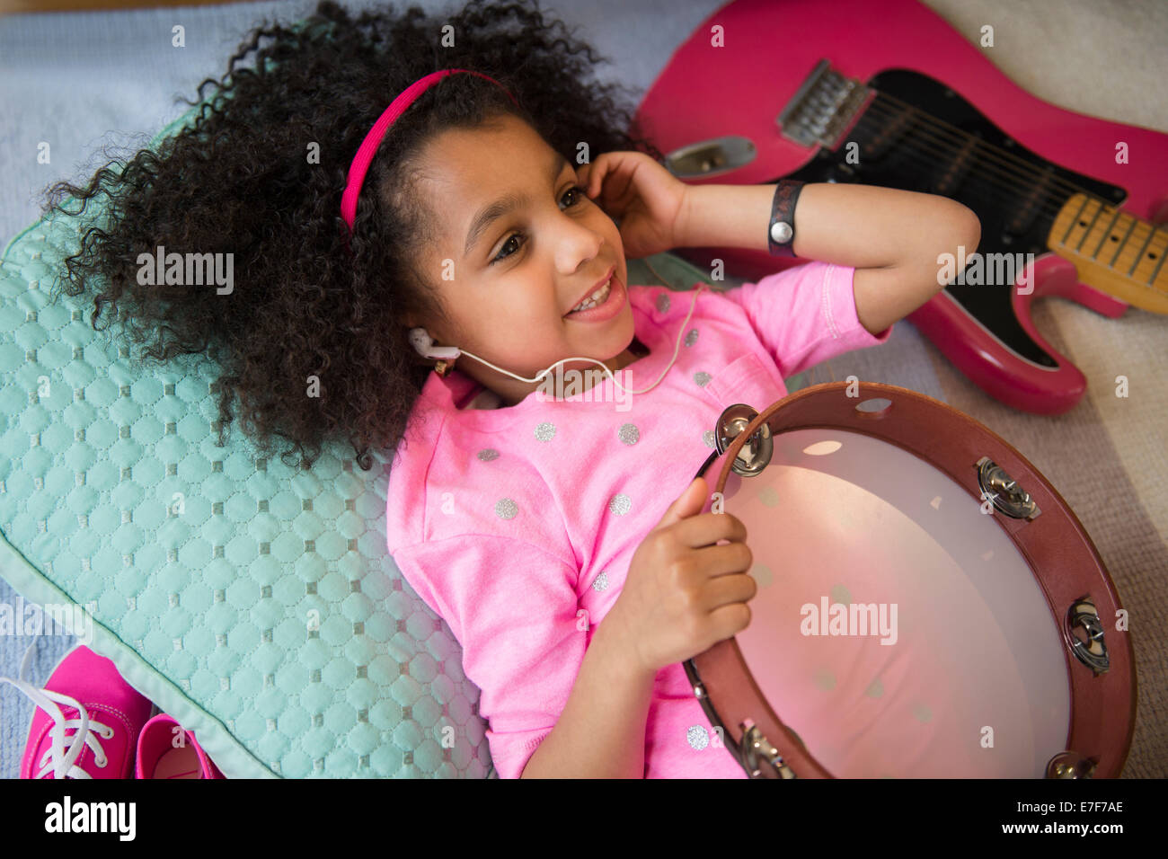 African American girl listening to music holding tambourine Stock Photo