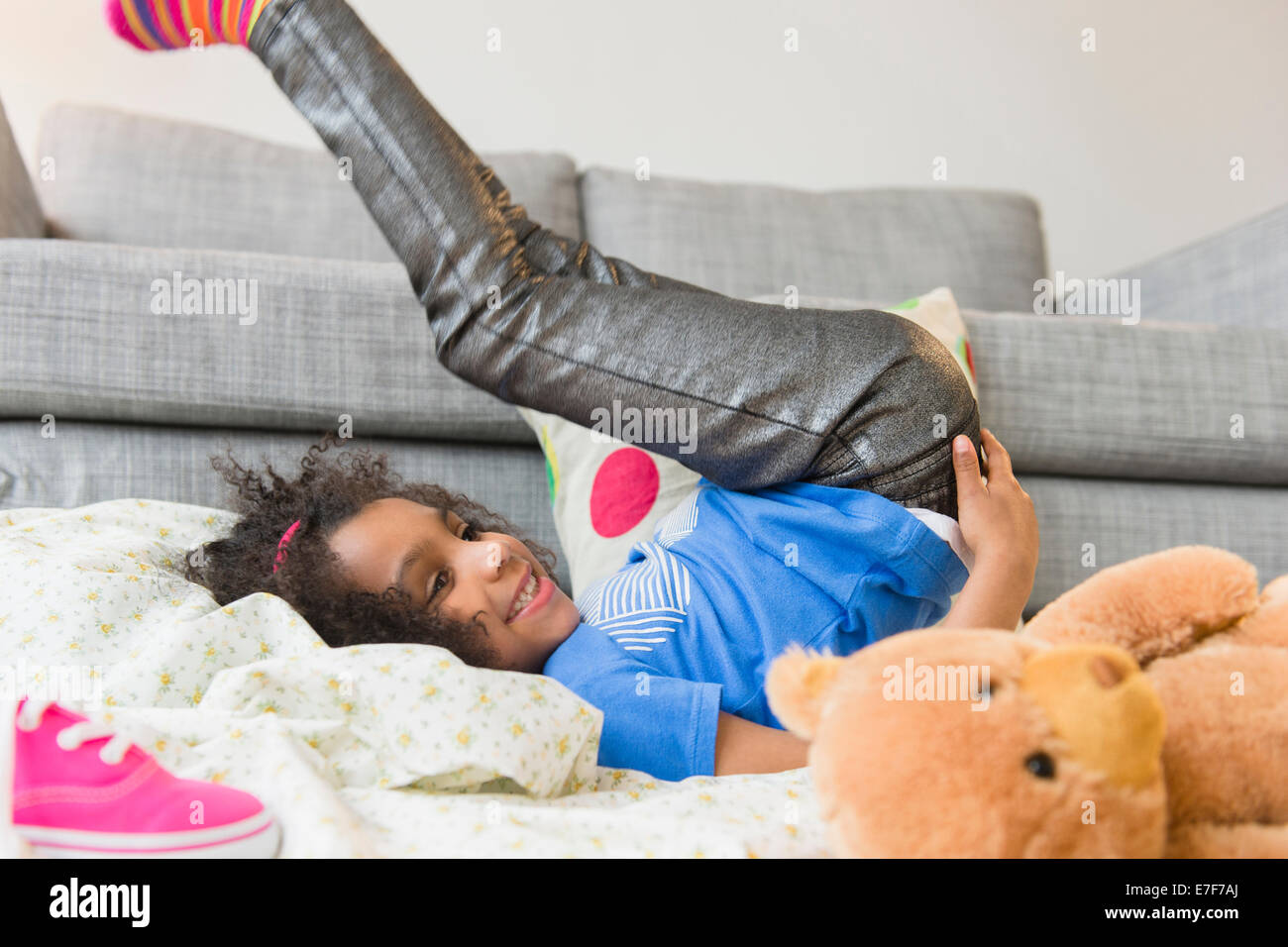 African American girl playing on living room floor Stock Photo