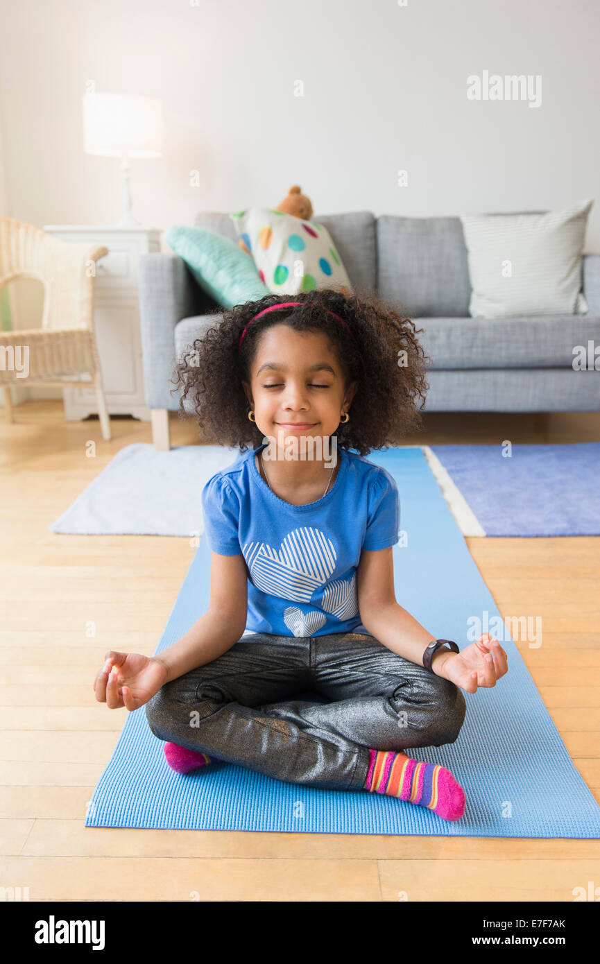 African American girl meditating on yoga mat Stock Photo Alamy