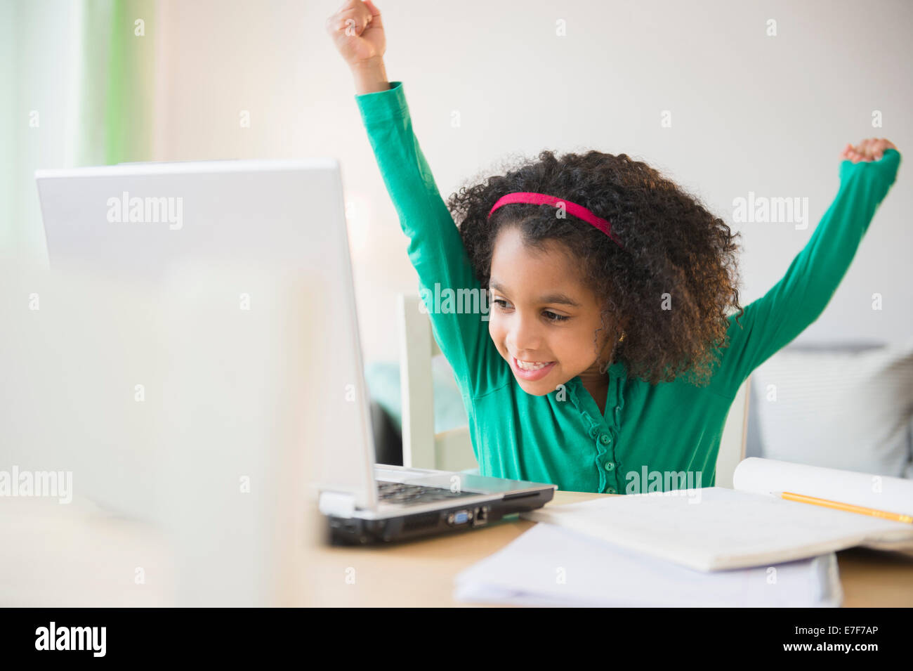 African American girl cheering at laptop Stock Photo