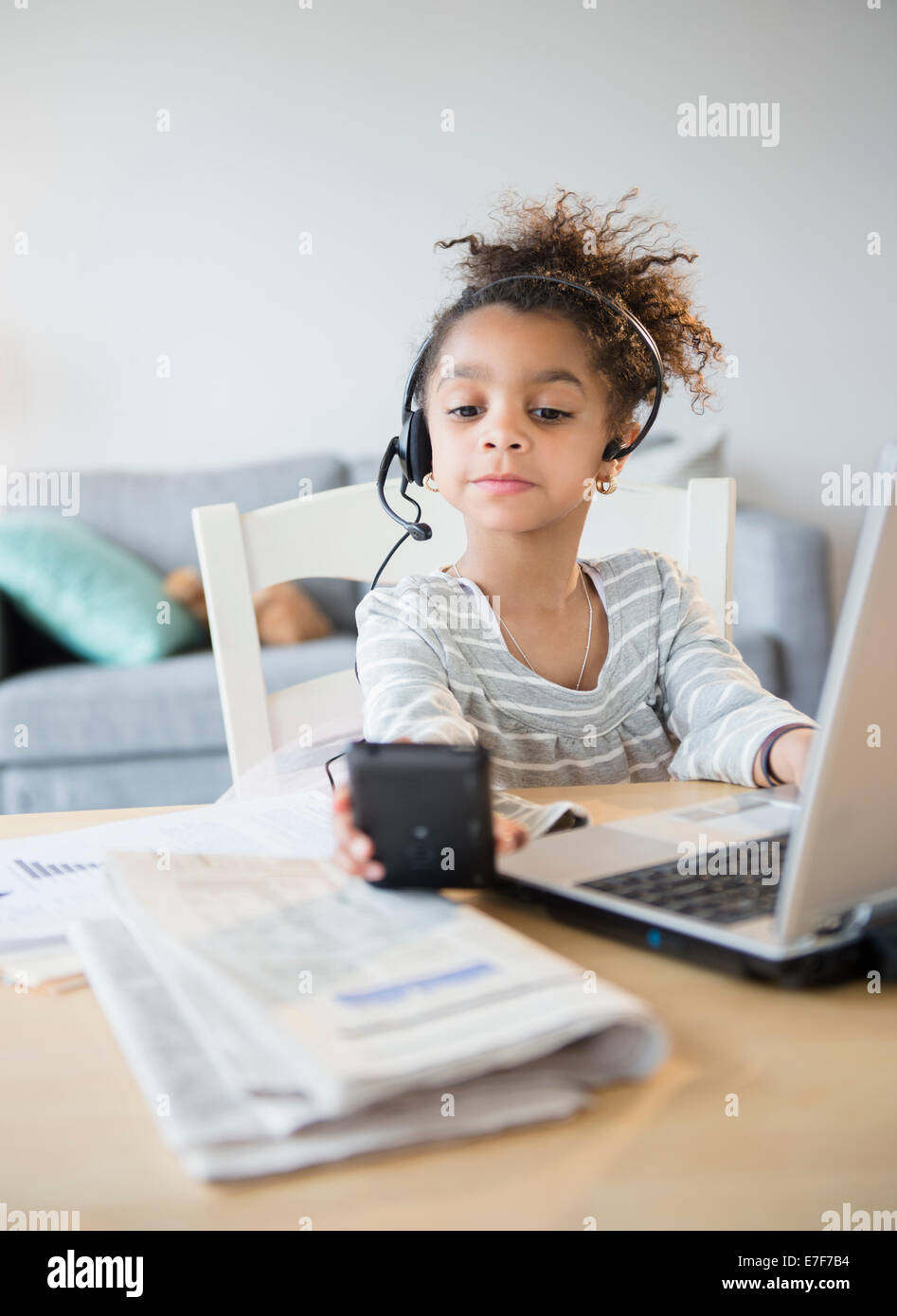 African American girl using headset, cell phone and laptop Stock Photo