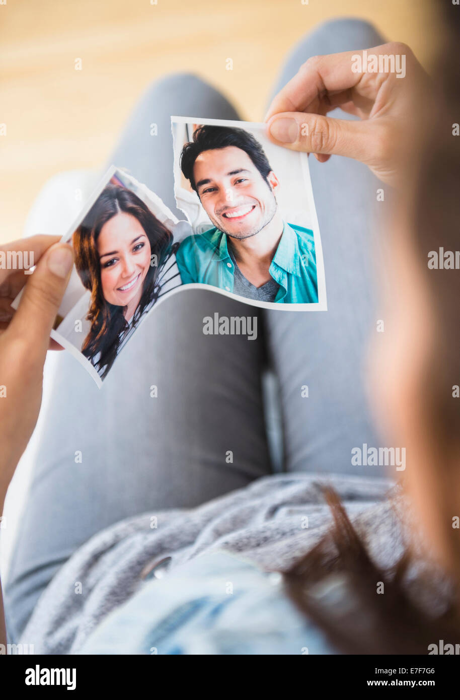 Woman tearing picture of herself with ex-boyfriend Stock Photo