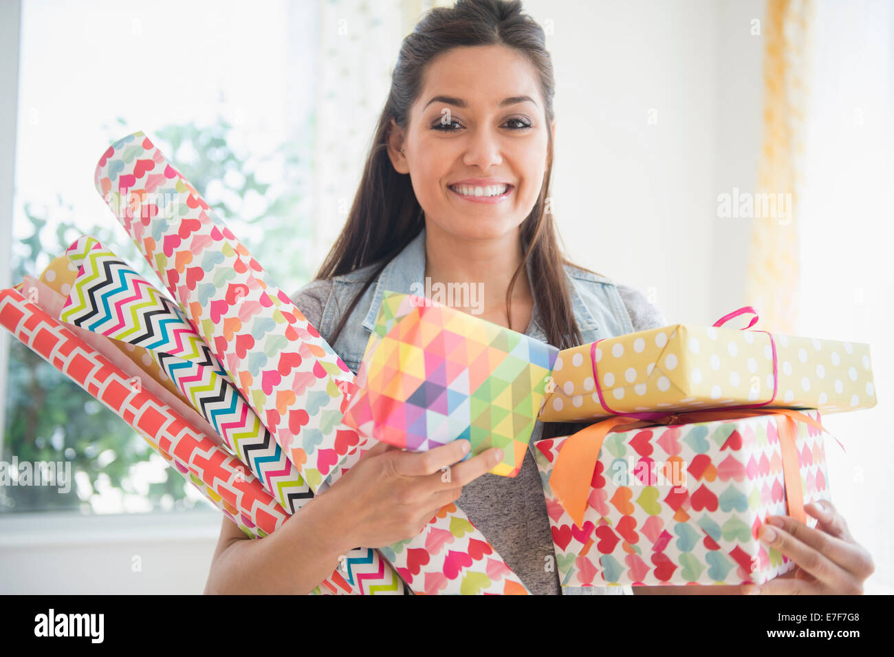 Woman carrying wrapping paper and gifts Stock Photo