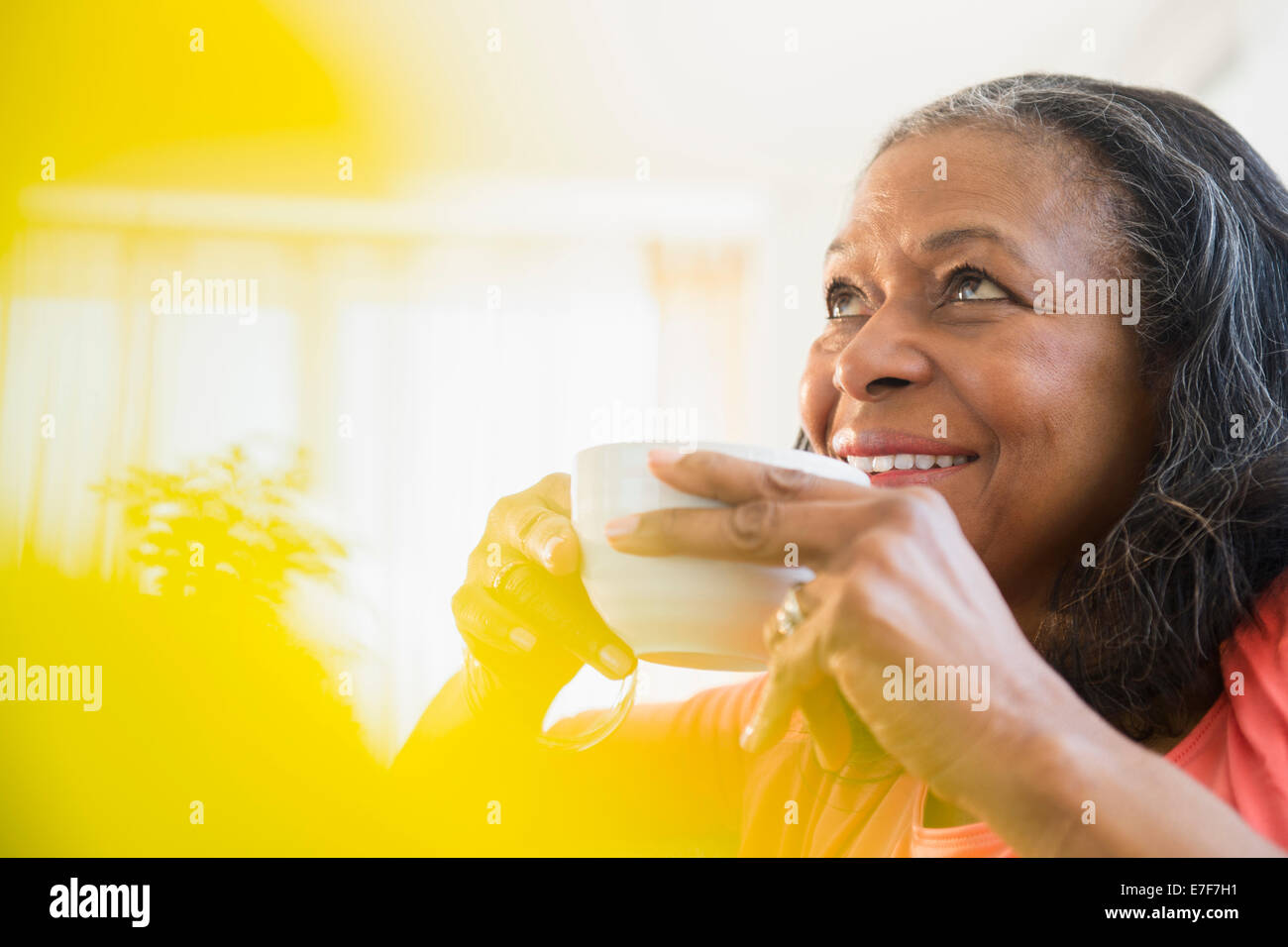 Mixed race woman drinking cup of coffee Stock Photo