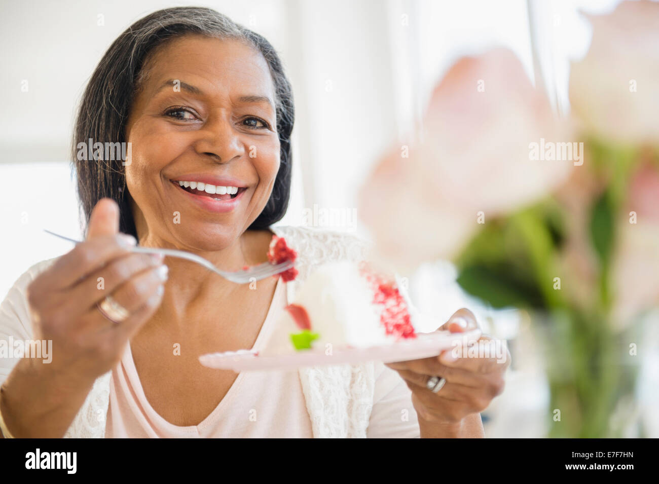 Mixed race woman sharing cake Stock Photo