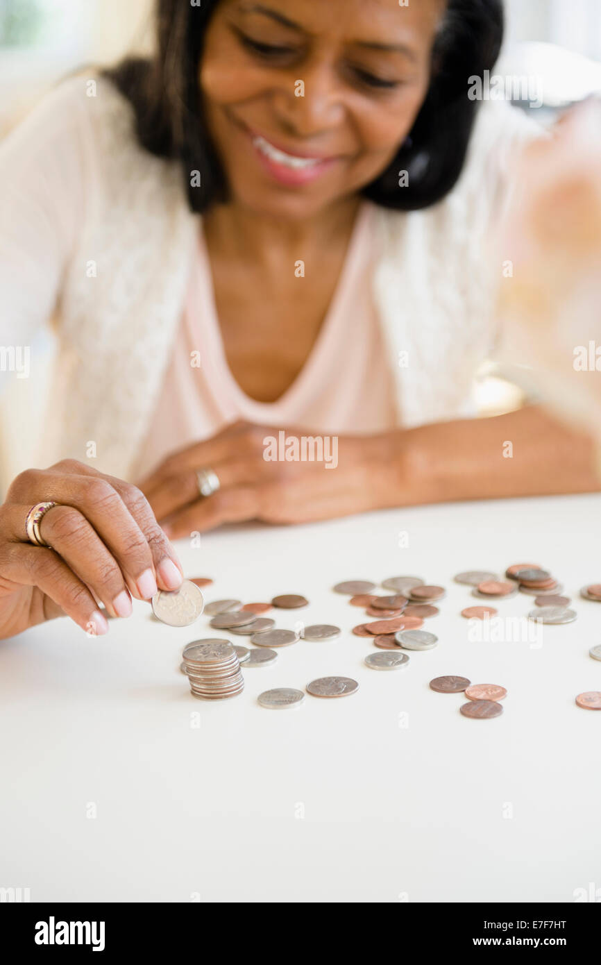 Mixed race woman counting change Stock Photo