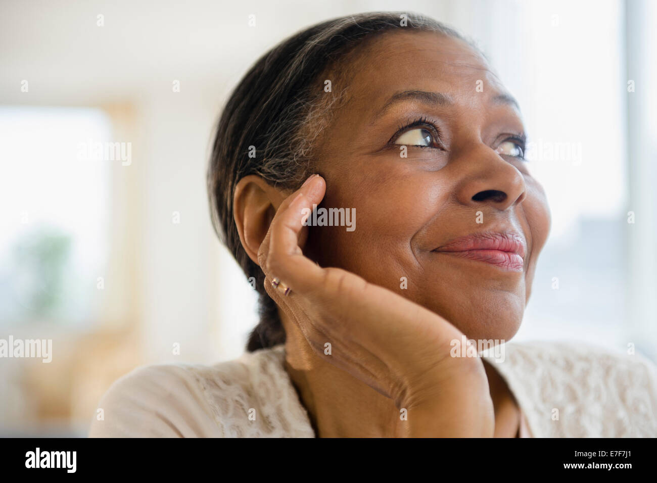 Close up of mixed race woman resting chin in hand Stock Photo