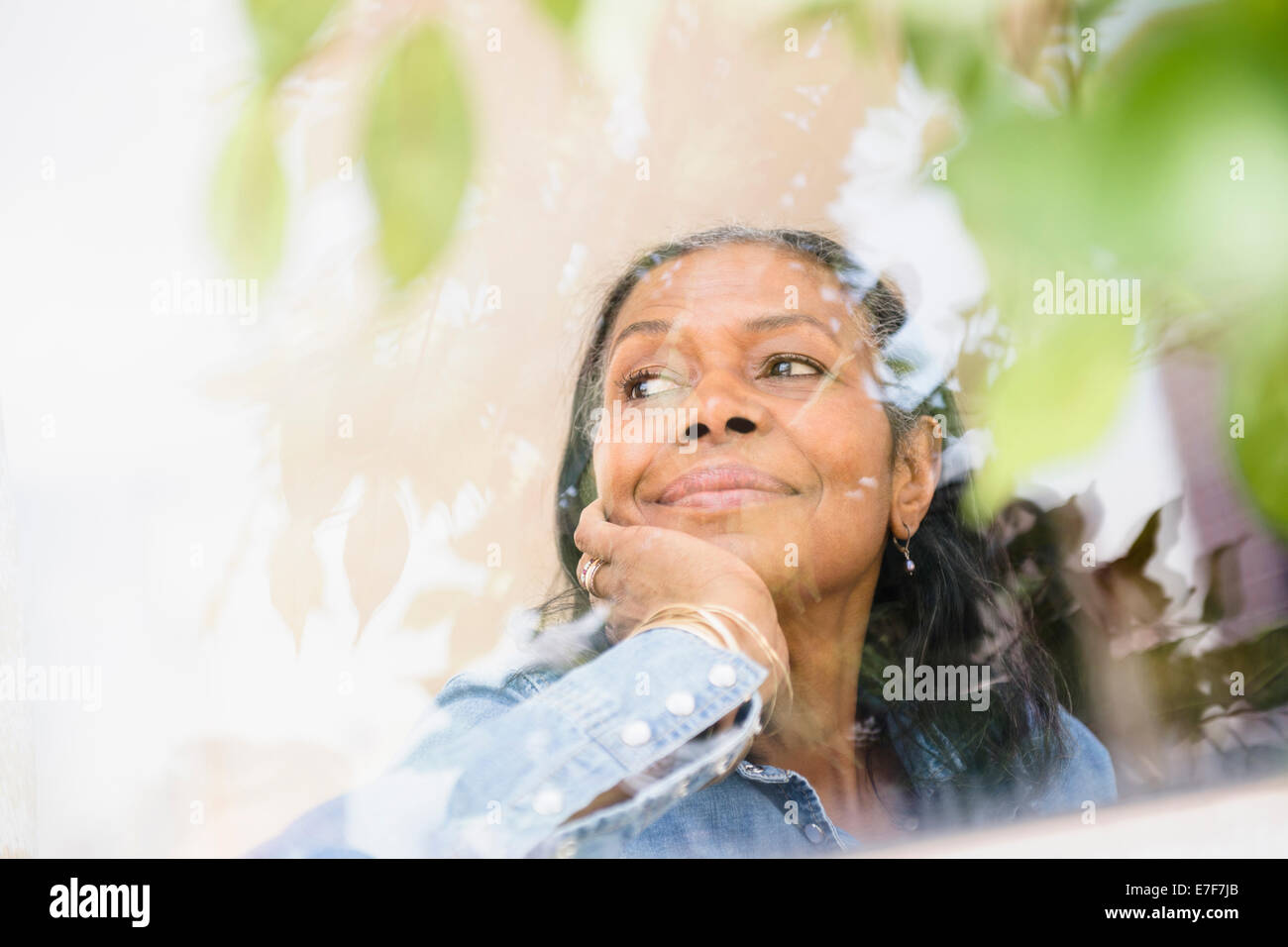 Mixed race woman looking out window Stock Photo