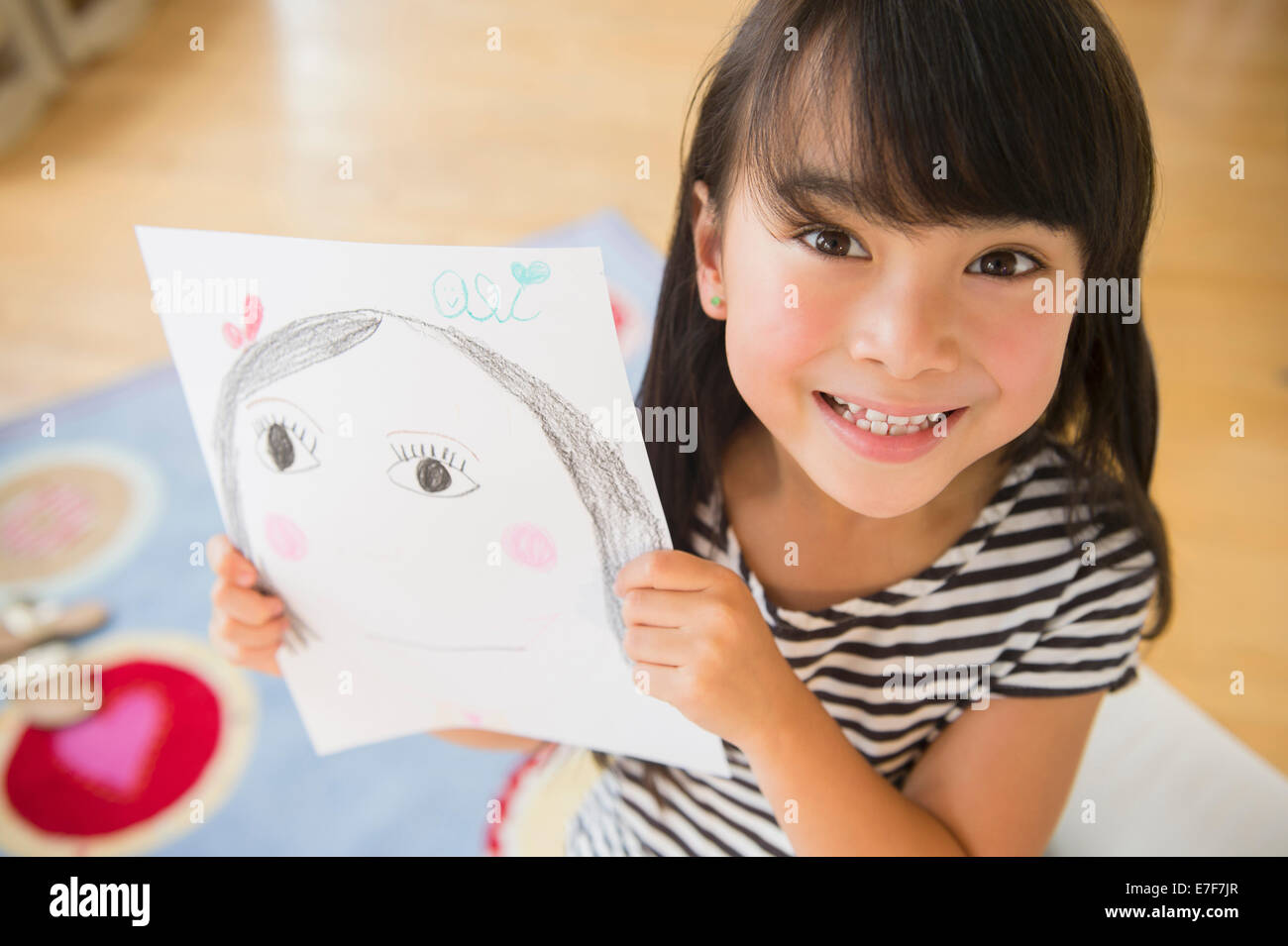 Filipino girl displaying drawing in bedroom Stock Photo