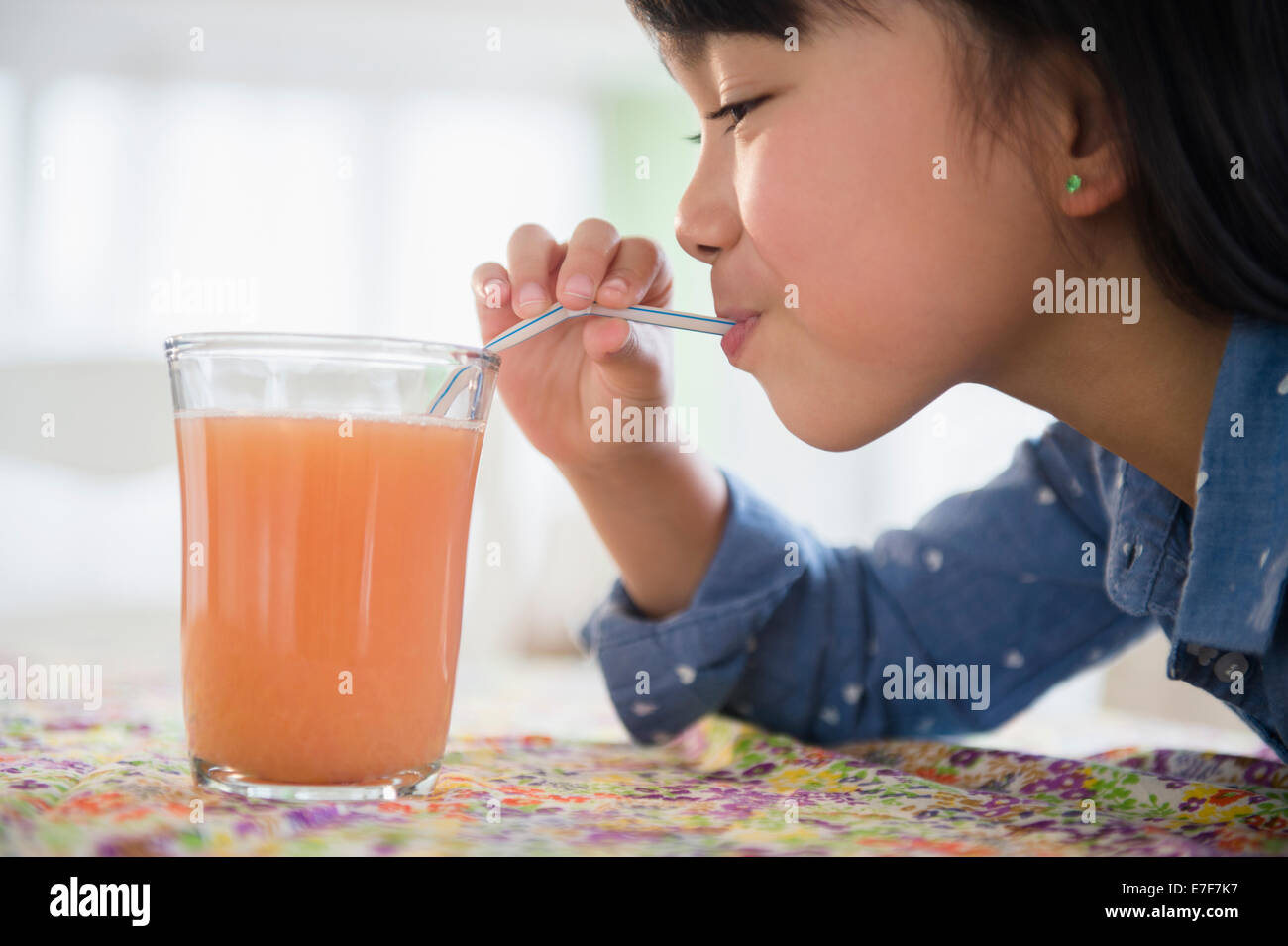 Filipino girl drinking juice on table Stock Photo