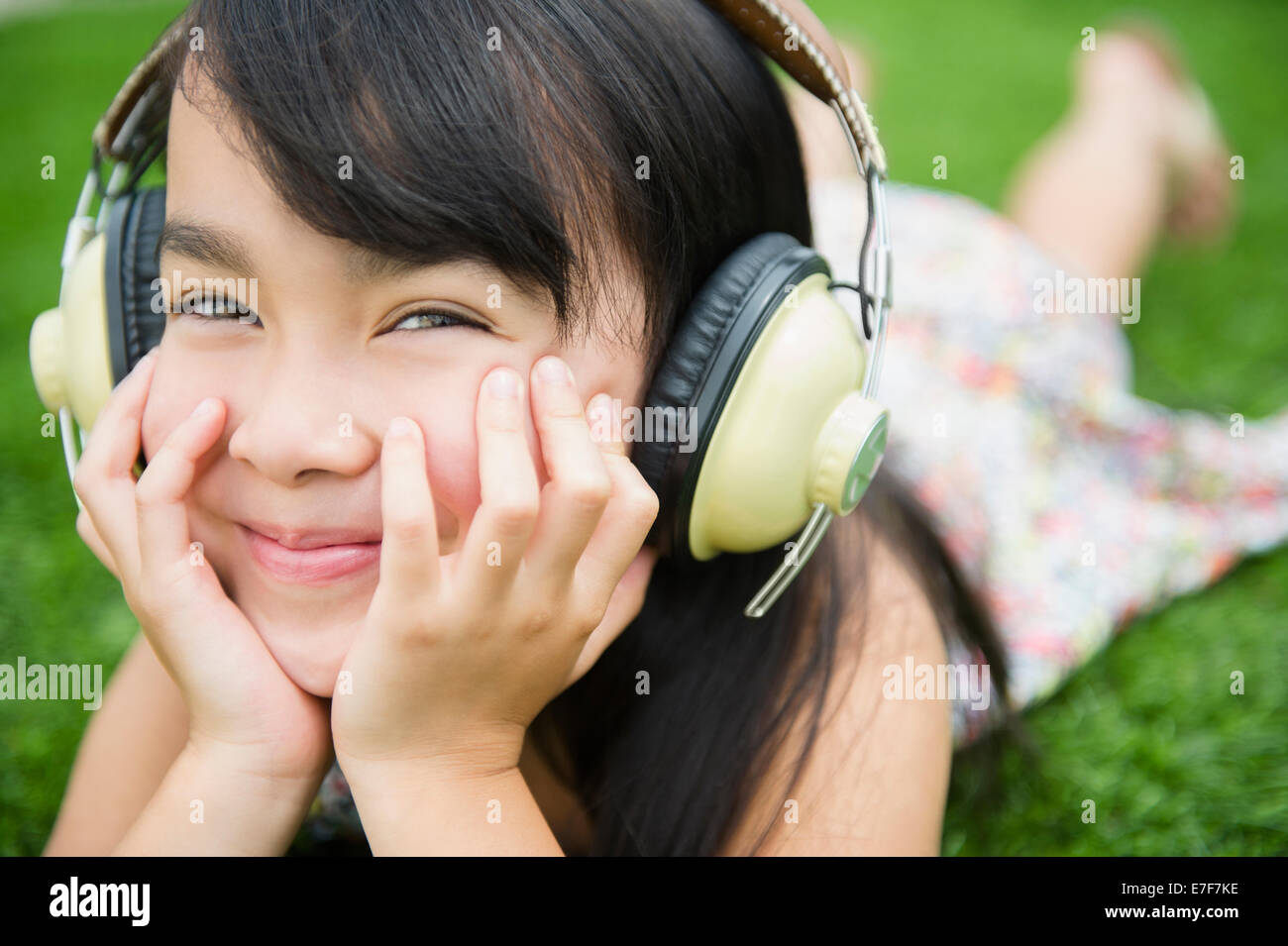 Filipino girl listening to headphones outdoors Stock Photo