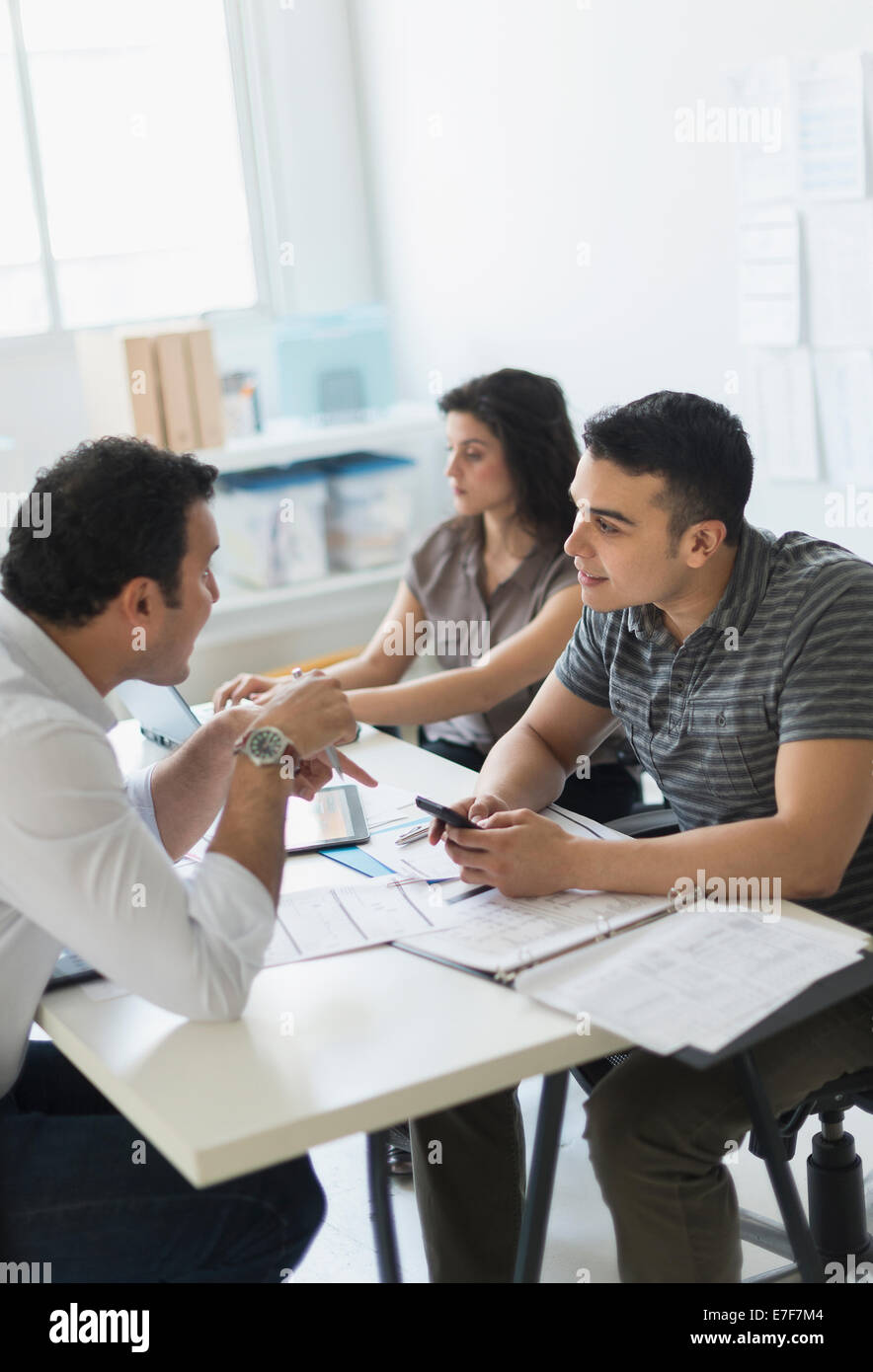 Hispanic business people working together in office Stock Photo