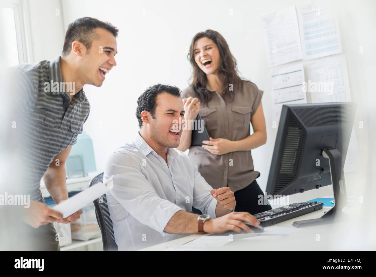Hispanic business people laughing together in office Stock Photo