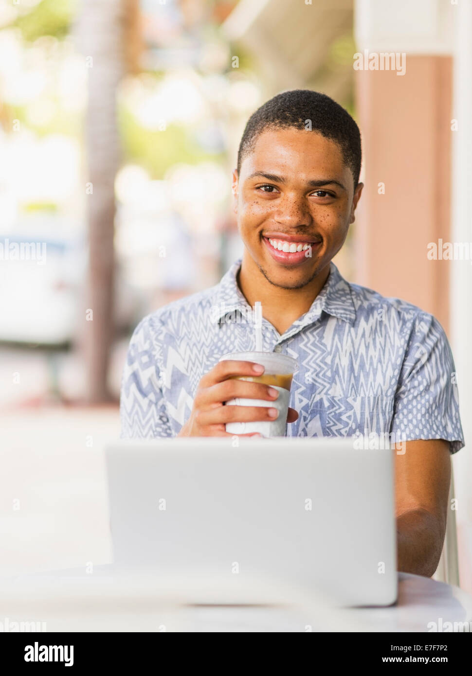 African American man using laptop in cafe Stock Photo