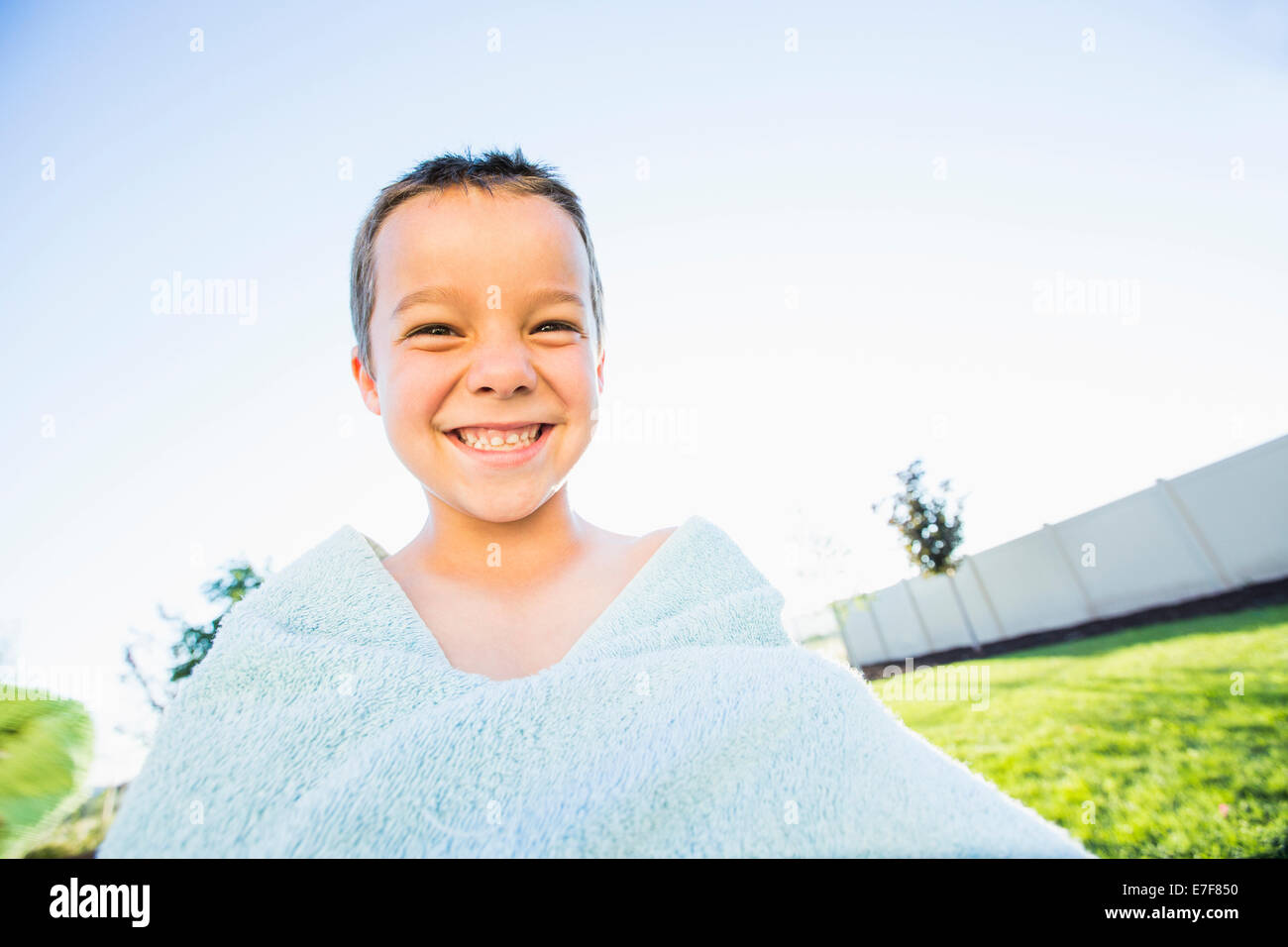 Caucasian boy playing with towel in backyard Stock Photo