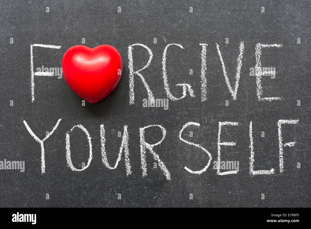 forgive yourself phrase handwritten on school blackboard Stock Photo