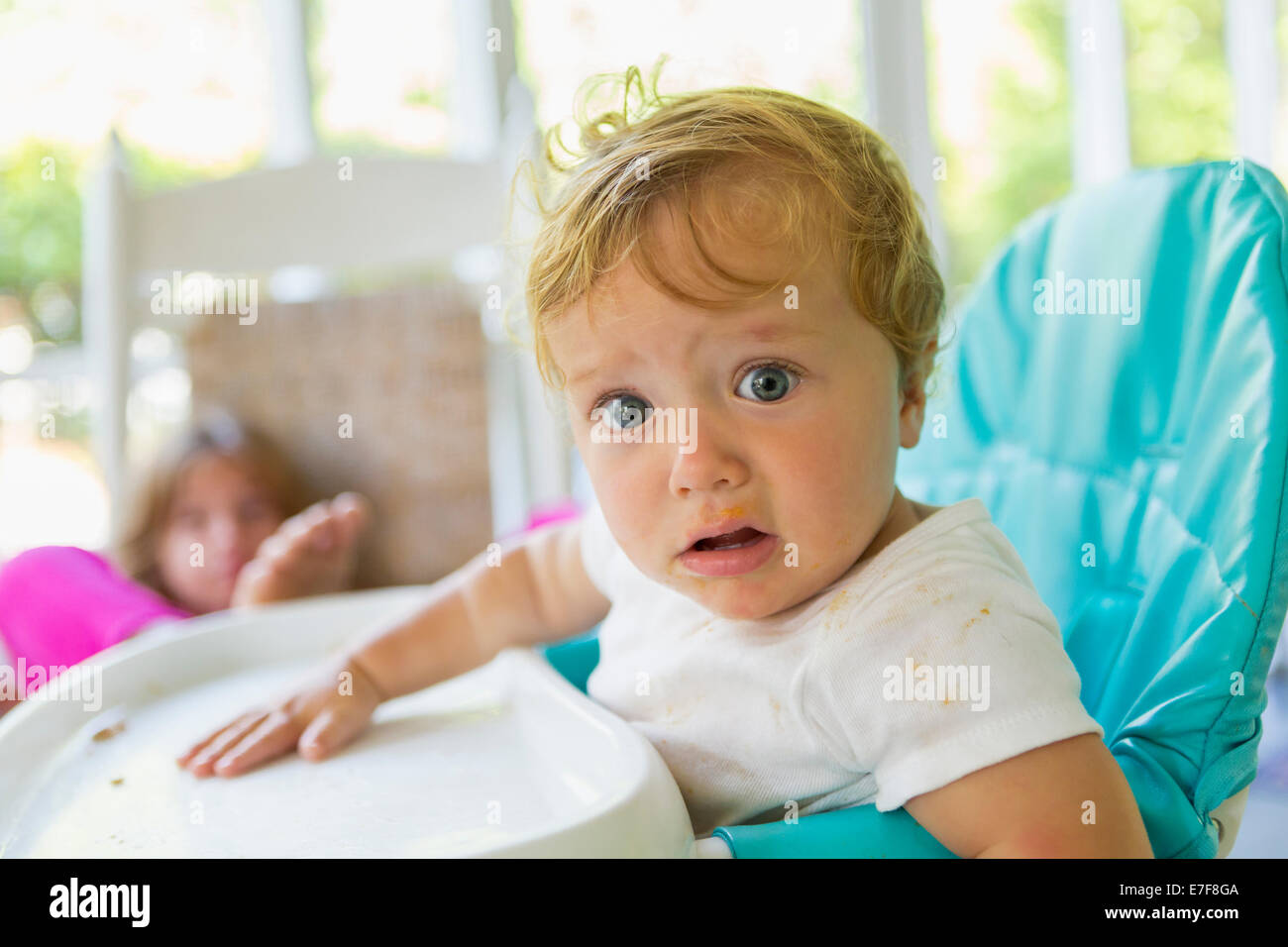 Caucasian boy sitting in high chair Stock Photo Alamy