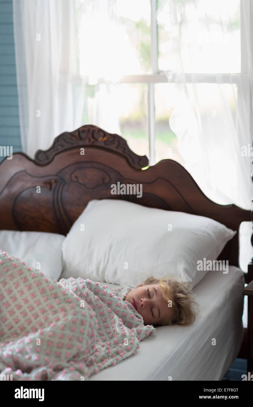 Caucasian girl asleep in bed Stock Photo