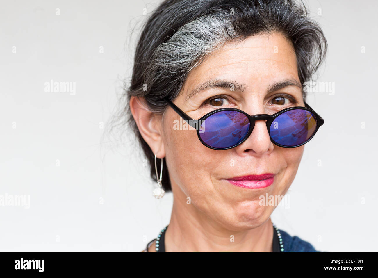 Older Hispanic woman wearing blue sunglasses Stock Photo