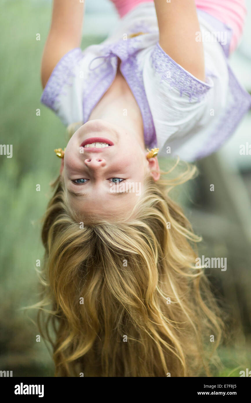 Young girl child playing in garden hanging upside down, MR#543