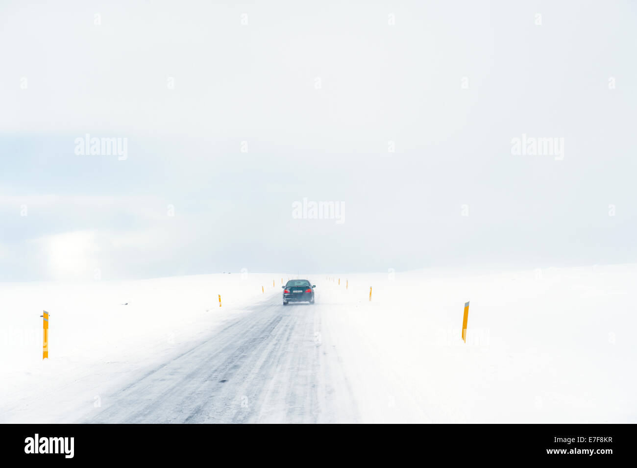 Car driving on rural road in snowy landscape Stock Photo