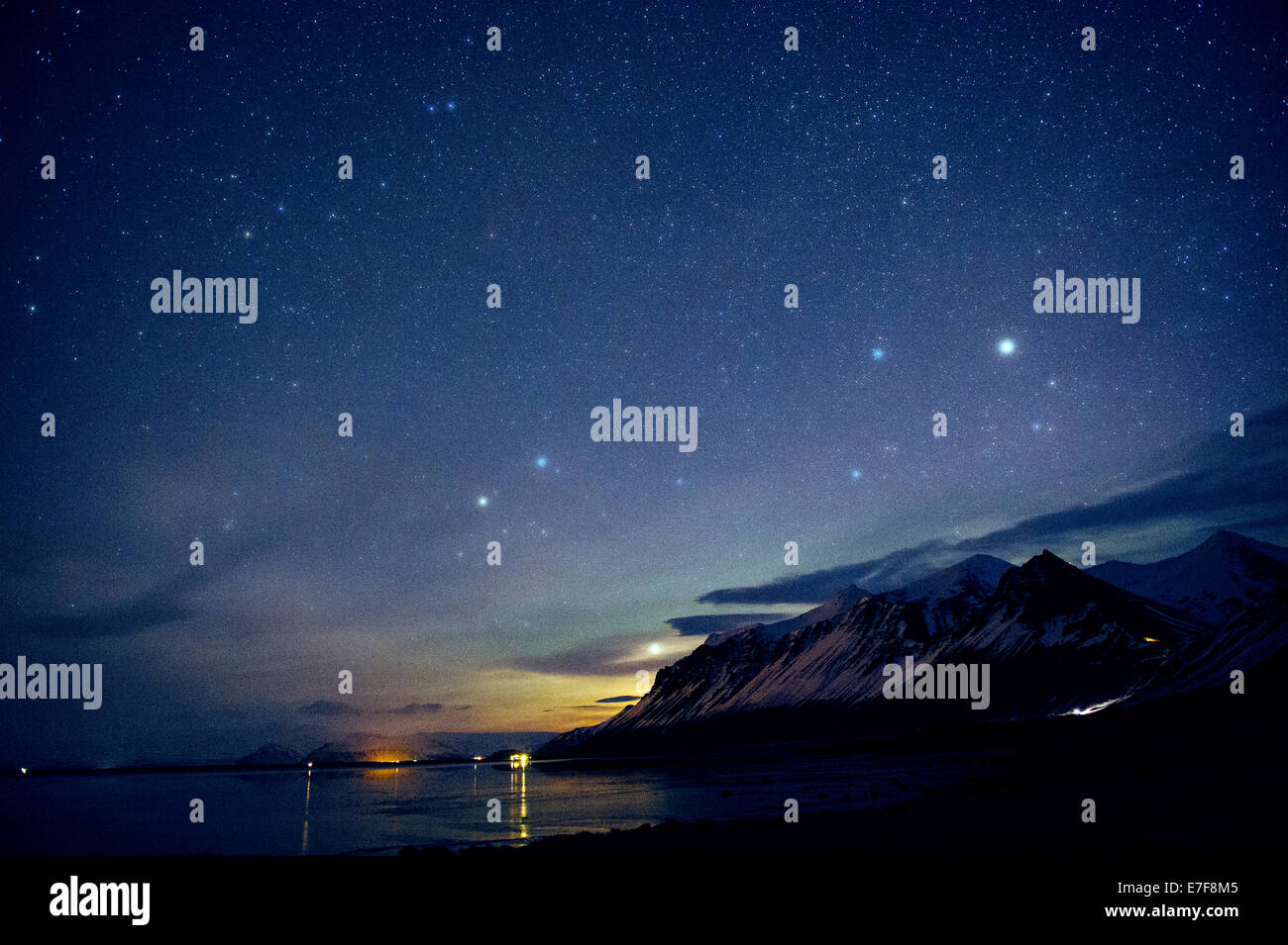 Starry sky over still ocean in arctic landscape Stock Photo