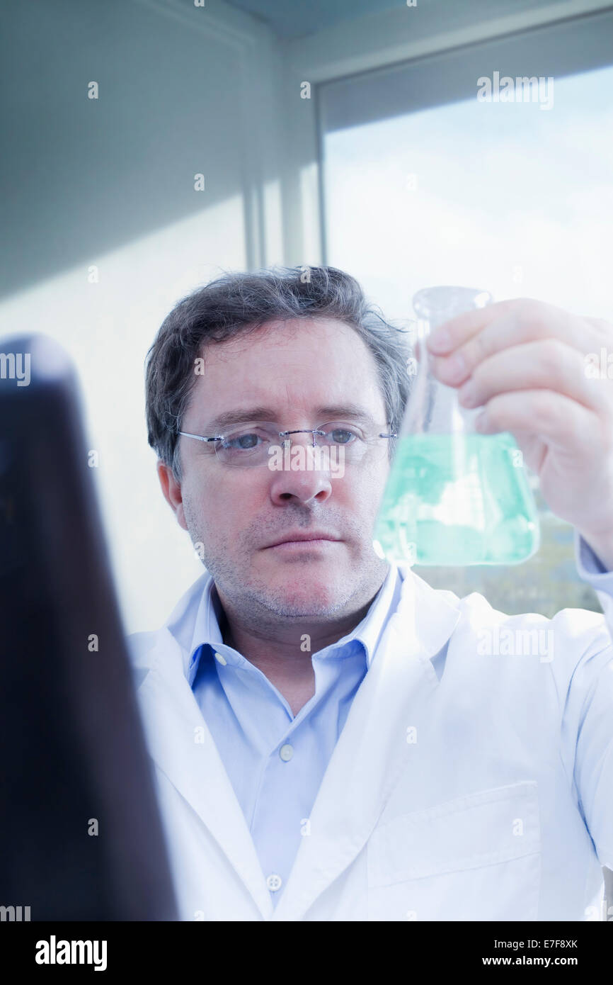 Hispanic scientist examining beaker in lab Stock Photo Alamy