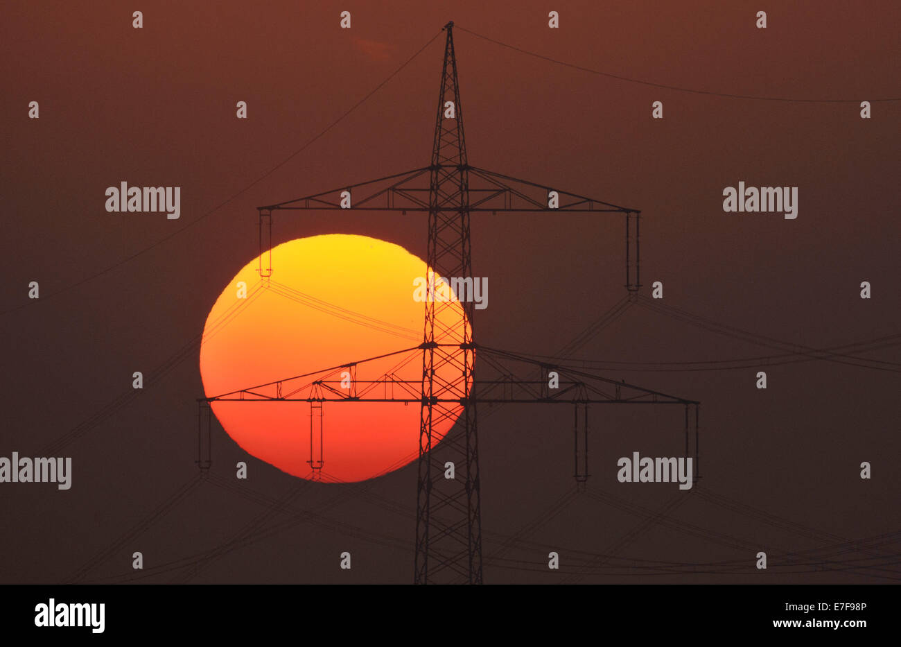 Sehnde, Germany. 16th Sep, 2014. Sunrise behind a power pylon near Sehnde, Germany, 16 September 2014. Indian summer, or Altweibersommer in German, is a weather phenomenon which often brings sunny weather between mid-September and the start of October. Photo: JULIAN STRATENSCHULTE/DPA/Alamy Live News Stock Photo