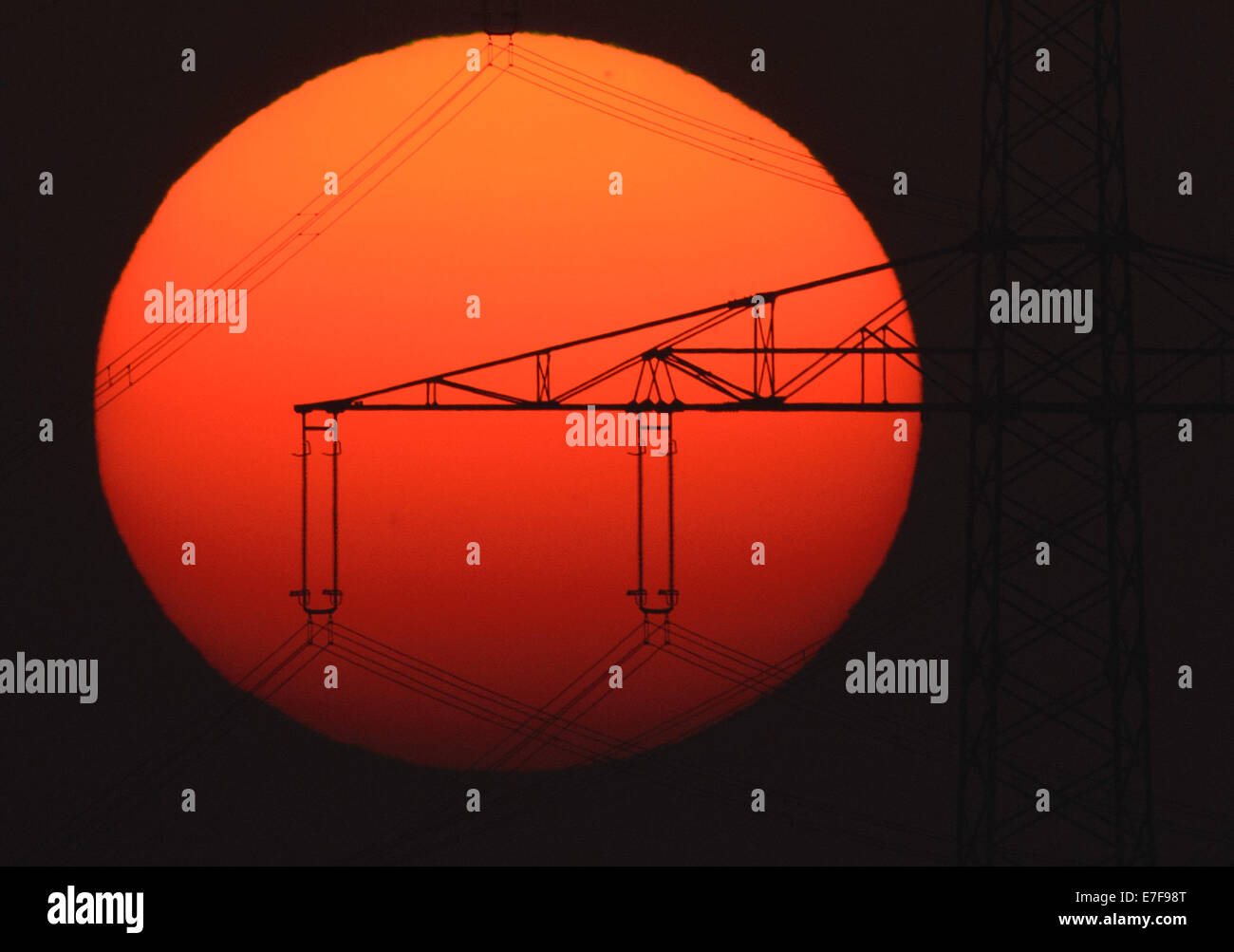 Sehnde, Germany. 16th Sep, 2014. Sunrise behind a power pylon near Sehnde, Germany, 16 September 2014. Indian summer, or Altweibersommer in German, is a weather phenomenon which often brings sunny weather between mid-September and the start of October. Photo: JULIAN STRATENSCHULTE/DPA/Alamy Live News Stock Photo