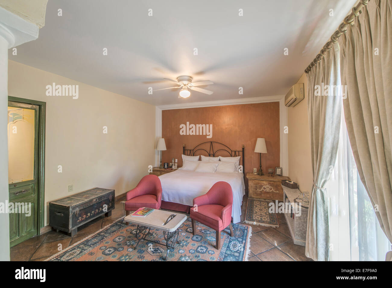 Bed, chairs and trunks in traditional hotel room Stock Photo