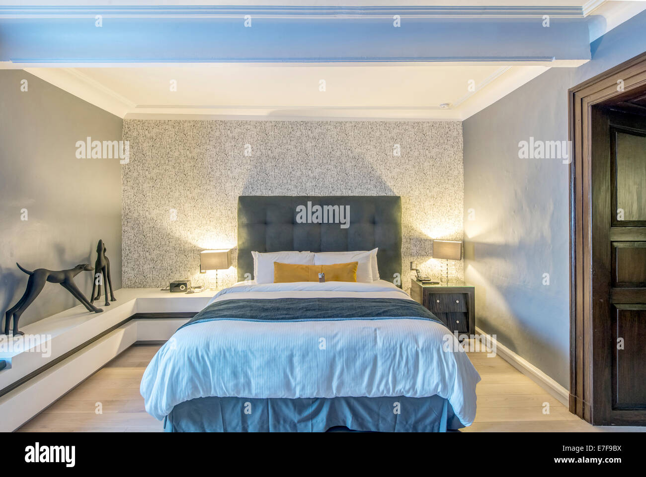 Bed, lighting and art in modern hotel room Stock Photo