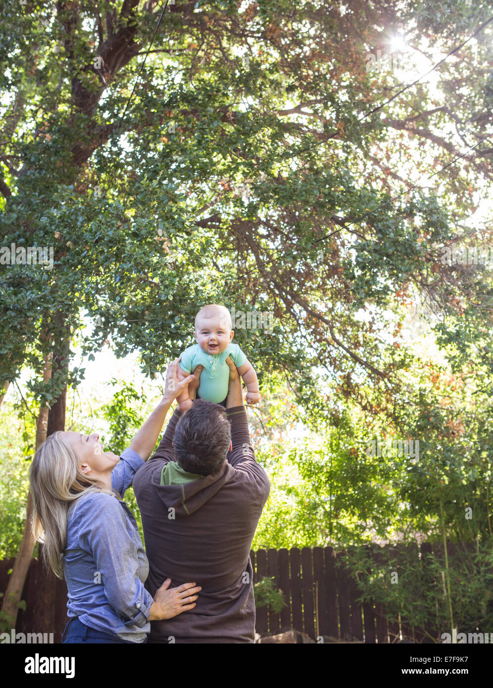 Caucasian couple playing with baby in backyard Stock Photo