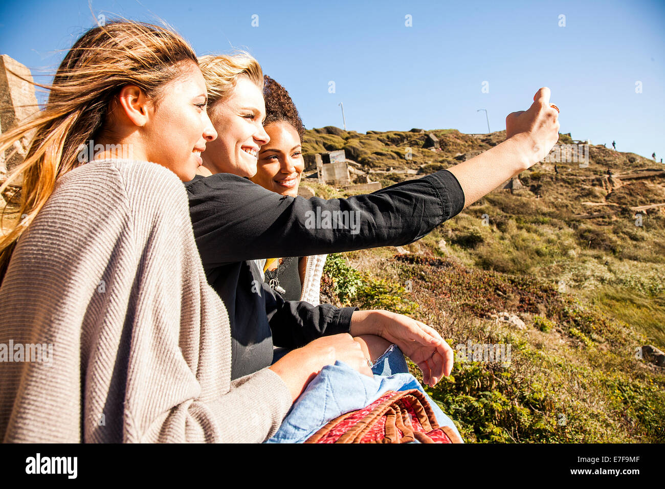 Women taking cell phone picture together on rural hillside Stock Photo