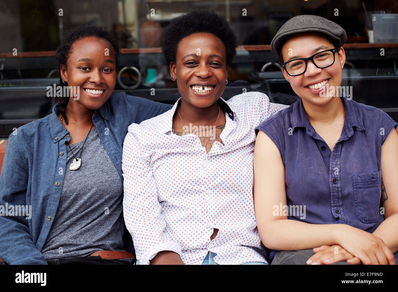 Women smiling outside coffee shop on city street Stock Photo