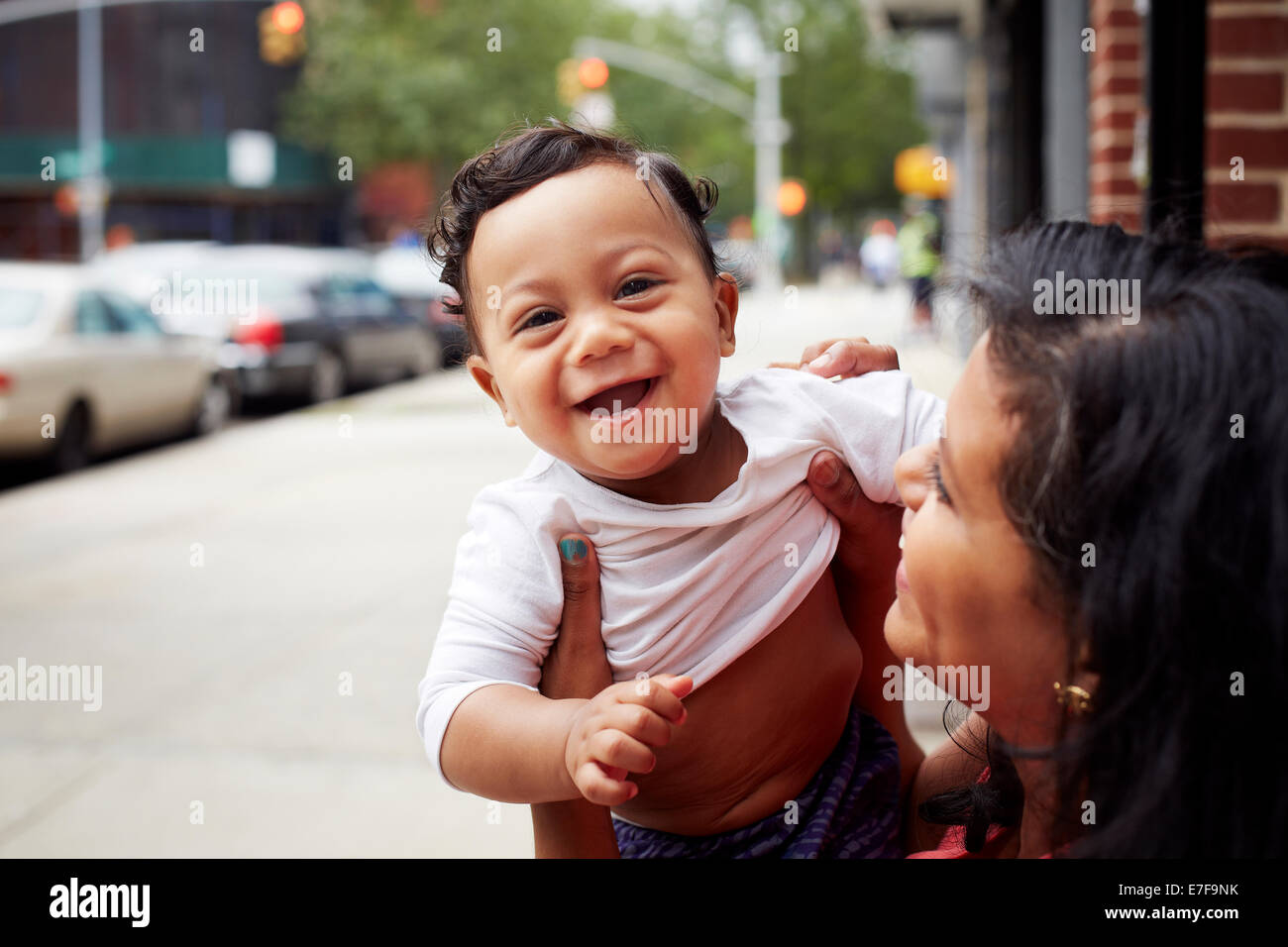 Mother playing with toddler son on city street Stock Photo