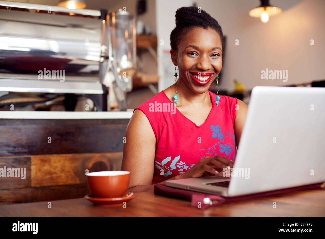 Woman using laptop in cafe Stock Photo