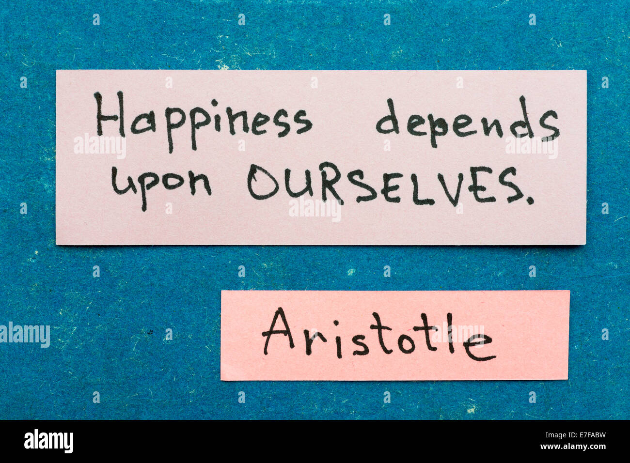 famous ancient Greek philosopher  Aristotle quote interpretation with sticky notes on vintage carton board about happiness Stock Photo
