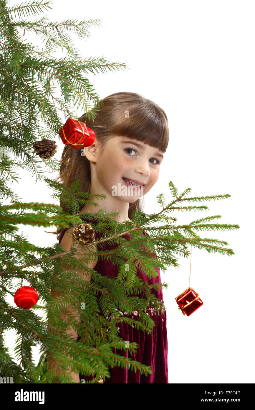 Cute girl behind the Christmas tree. Portrait isolated on white background Stock Photo