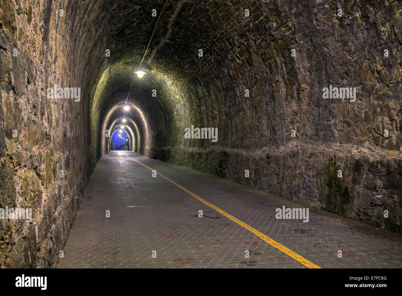 stone tunnel with yellow light Stock Photo